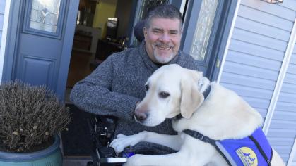 Javier Robles photographed at home with his guide dog Delbert