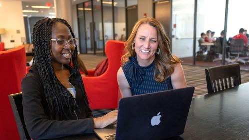 Izabellar Tulasi (SAS '27) shows work on laptop to Kristen Syrett, professor Linguistics, and Center for Cognitive Science in the lounge of Honors College