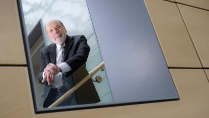 Kenneth J. Breslauer posing on a stairwell through a window