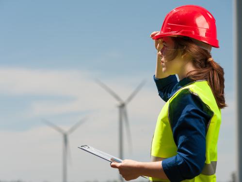 Engineer in front of Wind Turbines in the distance