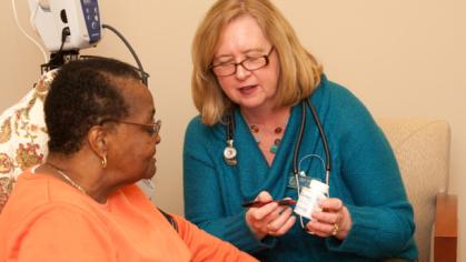 patient with a medical practitioner holding a bottle of medicine