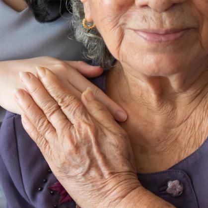 older asian female holding young girl's hand