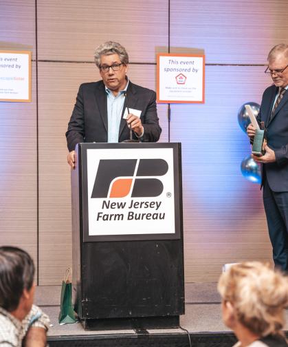 Jim Simon giving acceptance speech while NJ Farm Bureau President Allen Carter looks on 