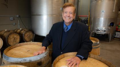 Angus Gillespie standing by wine vats